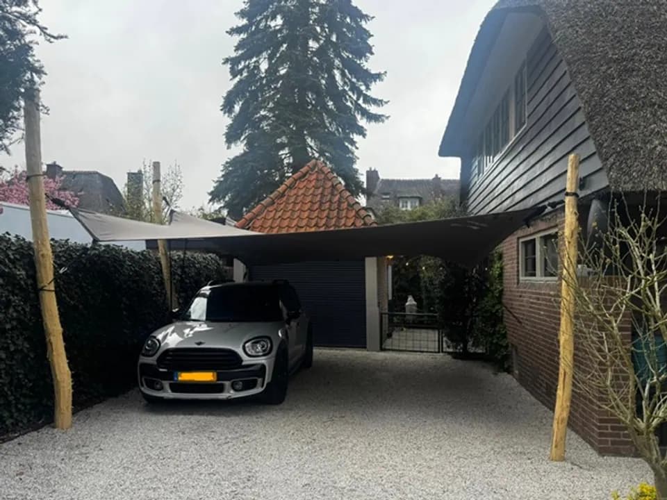 Auto onder een op maat gemaakte carport van stretchdoek